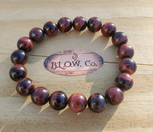 Load image into Gallery viewer, This bracelet is available in 8mm and 10mm. Red Tigers eye is a stimulating stone and can support motivation and a more active sex drive. It's focus on the lower chakras is what gives Red Tiger Eye the power to send higher energies through the organs of the lower half of the body. Red Tiger Eye aids in enhancing confidence and self-esteem as well. It provides motivation to the non-motivated and energizes those who are feeling lethargic.